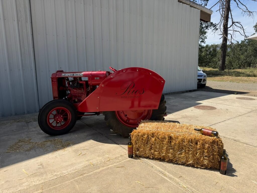 red tractor next to bale of hay