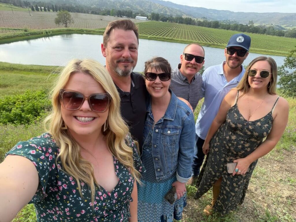 group of people smiling in vineyard