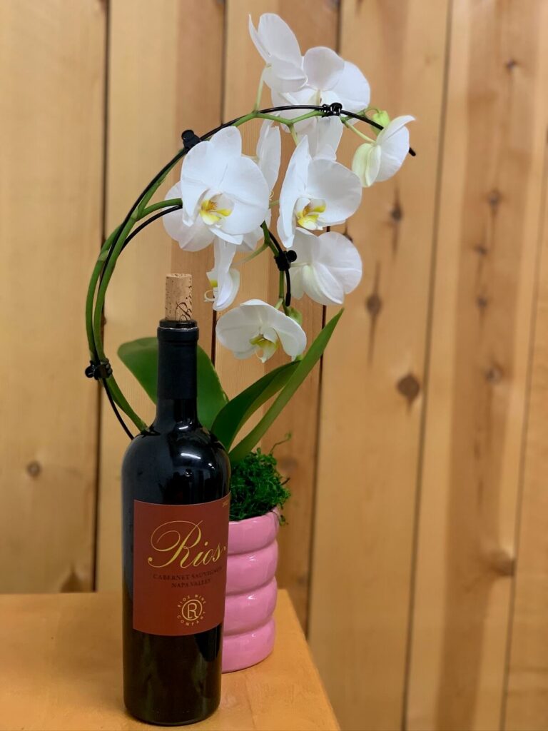 wine bottle next to orchid